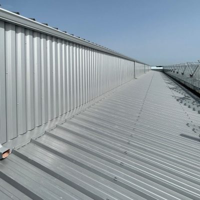 Installation de gouttières en G400 corniche pour un bâtiment industriel en couleur gris alu ral 9006