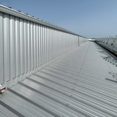 Installation de gouttières en G400 corniche pour un bâtiment industriel en couleur gris alu ral 9006